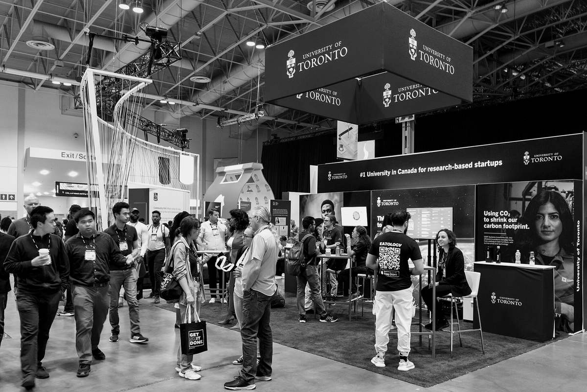 A busy conference floor, people walking between the booths